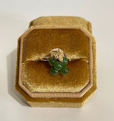 "Vintage 14k Jade Nephrite Bunch of Green Grapes Bead Cluster Ring, This lovely vintage ring has genuine Nephrite Jade beads in a grape cluster style. An etched grape leaf of gold adorns the top of the bunch. The ring is stamped and tested 14k yellow gold. ERA - Circa 1960s / Mid Century  METAL / MATERIAL - 14k yellow gold, genuine nephrite jade  MARKINGS / HISTORY - Inside band is marked \"14k\" CONDITION - Good vintage condition. Yellow gold metal has been  polished & cleaned. Age appropriate patina & wear remains. Genuine nephrite jade secure. Amazing vintage genuine nephrite jade ring!  SIZE / MEASUREMENTS - Size: 5 1/2, Jade balls measure: 5mm each,Ring Head Height: 16.3 mm, Rise Of Ring Off Finger: 9.8 mm, Shank: 2.1 mm, Weight: 2.44grams https://www.etsy.com/shop/LastCenturyJewels" Vintage 14k Gold Green Emerald Ring, Mid-century Green Collectible Jewelry, Mid-century Yellow Gold Round Jewelry, Mid-century Round Yellow Gold Jewelry, Vintage Jade Ring As A Gift, Vintage Jade Ring As Gift, Vintage Jade Rings As Gifts, Vintage 14k Stamped Emerald Gift Ring, Vintage Jade Rings For Anniversary