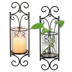 two metal planters with candles in them and one has a green plant inside it