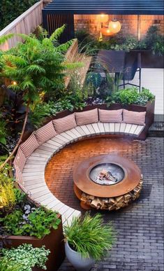 an outdoor fire pit surrounded by potted plants