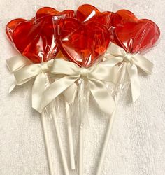 four heart shaped lollipops wrapped in cellophane