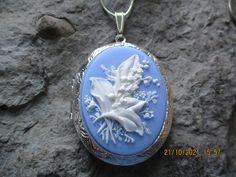 "Beautiful cameo locket. The cameo is a gorgeous lily of the valley. Stunning colors. I have this in so many colors, finishes and styles so please do browse. The bronze or silver locket is Victorian style with beautiful etching on the front and back about 2\" long, please see the photo for size. It can hold two photos or a treasured keepsake. Pass down from generation to generation. The chain is 24\" bronze link chain with a lobster claw clasp. For the silver is a 24\" silver plated snake chain. Flower Shaped Locket Jewelry For Wedding, Floral Wedding Locket Jewelry, Flower Shaped Wedding Locket Jewelry, Wedding Flower Locket Jewelry, Blue Cameo Necklace For Wedding, Blue Cameo Jewelry For Wedding, Blue Medallion Necklace For Wedding, Blue Engraved Necklaces For Wedding, Blue Medallion Necklaces For Wedding