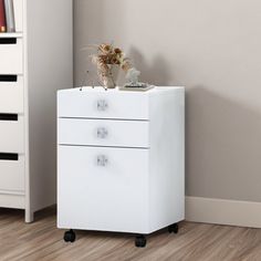 a white filing cabinet sitting next to a book shelf