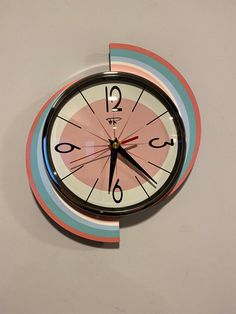 a clock that is on the side of a wall and has numbers painted on it