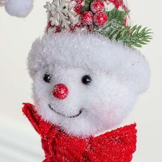 a white teddy bear wearing a red scarf and hat with snowflakes on its head