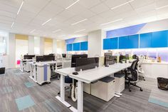 an empty office with desks and chairs in the middle of the flooring area