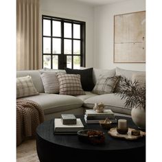 a living room with a large sectional couch and coffee table in front of a window