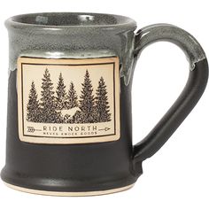 a black coffee mug with the words ride north on it and trees in the background