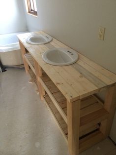 a bathroom with two sinks and a bathtub in the corner, all made out of pallet wood