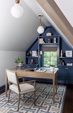 an attic office with built - in shelving and desk