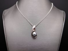 Estate 14kt White Gold Genuine Black Tahitian South Sea 11mm Pearl & .05ct Diamond Pendant. Set into this wonderful, 1 inch by 1/2 inch, pendant is 1 Fine Quality Black Tahitian South Sea Pearl which measures 11mm. The Pearl is black/gray with strong luster and nacre thickness and very few blemishes. Also set is 1 fine quality Round Brilliant Cut Diamonds H color, SI-1 clarity weighing 0.05cts total approx. This beautiful Estate 14kt White Gold 11mm Black South Sea Pearl & Diamond Pendan Tahitian Pearl Pendant Necklaces For Formal Occasions, Formal Tahitian Pearl Pendant Necklaces, Fine Jewelry Tahitian Pearl Necklace For Anniversary, Tahitian Pearl Round Pendant Necklace For Anniversary, Tahitian Pearl Fine Jewelry Necklace For Anniversary, Tahitian Pearl Necklace For Anniversary, Fine Jewelry Tahitian Pearl Pendant Necklace, White Gold Tahitian Pearl Jewelry For Anniversary, Silver Tahitian Pearl Necklace Fine Jewelry