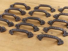 a bunch of iron handles sitting on top of a wooden table next to each other