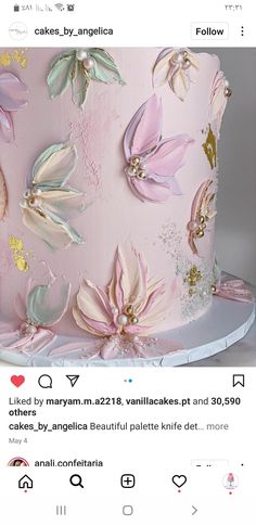 a pink and gold cake with flowers on it