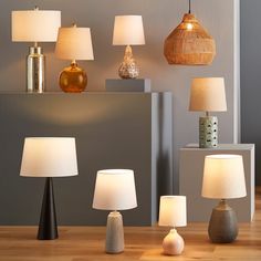 a collection of lamps sitting on top of a wooden table