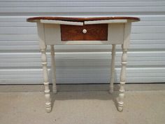 a white table with a wooden drawer on it