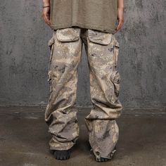 The Multi-Pocket Desert Cargo pants seamlessly blend street style with military aesthetics. Featuring an all-over camo print, these pants have a unique scimitar-like shape that creates natural creases, enhancing their edgy look. The multiple pocket design adds both functionality and a rugged appeal. Made from premium 100% cotton fabric, these pants ensure comfort and durability. The slightly oversized fit provides a relaxed, contemporary silhouette, making them an ideal choice for those who appr Baggy Combat Cargo Pants In Khaki, Baggy Combat Pants For Outdoor, Tactical Pants With Pockets For Streetwear, Tactical Streetwear Pants With Pockets, Camouflage Pants With Pockets For Outdoor Activities, Combat Pants With Patch Pockets For Streetwear, Outdoor Camouflage Cargo Pants With Side Pockets, Camouflage Techwear Pants For Outdoor Activities, Camouflage Techwear Pants For Outdoor