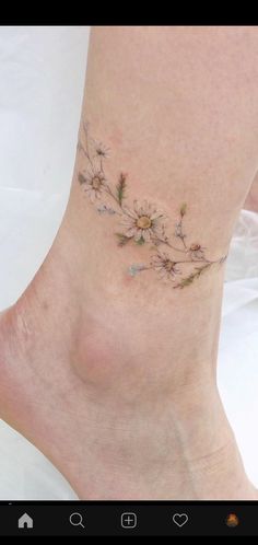 a woman's foot with flowers on it and the bottom part of her leg