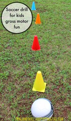 some plastic cones and a soccer ball in the grass with a speech bubble above it