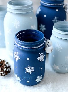 three blue mason jars with snowflakes on them