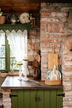 a kitchen with green cabinets and brick walls