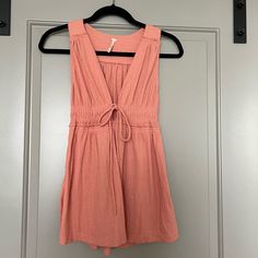 Free People Beach Bound Vneck Tank With Tie Front. Coral Pink/Orange Color. New With Tags In Perfect Condition Never Been Worn. Size Small Beachy V-neck Top For Day Out, Orange V-neck Top For Day Out, Cotton V-neck Beachwear Tops, Peach V-neck Top For Beach, Pink Sleeveless Beachy Top, V-neck Beachwear Top For Loungewear, Peach Summer Tops For The Beach, Summer Peach Tops For Beach, Peach Summer Tops For Beach