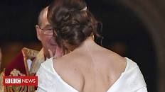 the back of a bride's dress as she walks down the aisle with her father