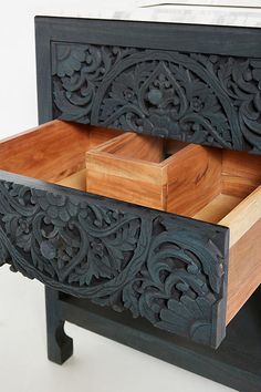 an intricately carved wooden chest with drawers on it's sides and the lid open