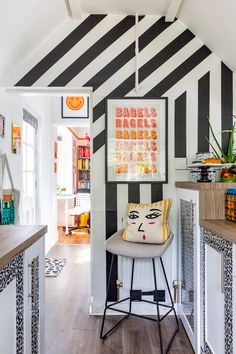 a black and white striped room with a bar stool in the corner next to it