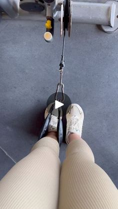 the legs and feet of a person on a pair of shoes, with an object attached to them