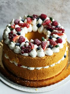 a cake with fruit on top sitting on a plate