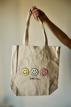 This is a handmade canvas tote bag made by me! The wording at the bottom is hand embroidered on but the faces are an iron on patch. super cute and trendy right now! It can be used for school, work, traveling, and so much more. the dimensions are 14.75 x 15 inches. Please message me for more details, I would be happy to provide! Tote Bag With Patches, Tod Bag, Patch Tote Bag, Decorated Bags, Bag Patches, Handmade Canvas, Farmers Market Bag, Embroidered Tote Bag, Embroidered Canvas