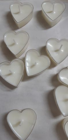 several white heart shaped candles sitting on top of a table