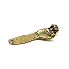 a gold colored metal object that looks like a hand holding something in it's right hand