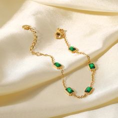 Introducing Elena's Emerald Elegance Bracelet, a dainty and sophisticated accessory that embodies grace and style. Crafted from high-quality stainless steel and plated with 18k gold PVD, this bracelet features sparkling colored crystal zircon and cubic zirconia accents. Perfect as a gift or a personal treat, it adds a touch of timeless beauty to any outfit. Green Stone Bracelet Gold, Green Gemstone Bracelet, Green Stone Bracelet, Spring Court, Geometric Bracelet, Emerald Bracelet, Gems Bracelet, Zirconia Necklace, Green Stones