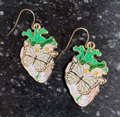 Anatomical heart with large butterfly and flowers/greenery. Gold plated backing and gold plate ear wires. Gold and cream colors with green accents. Heart Anatomical, Butterfly And Flowers, Flowers Earrings, Largest Butterfly, Anatomical Heart, Green Accents, Saint Paul, Flower Earrings, Ear Wires