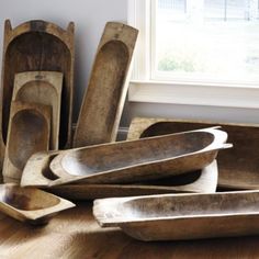 old wooden bowls and spoons are on the floor next to a window in an empty room