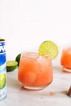 two glasses filled with watermelon and lime next to a can of soda