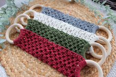 three crocheted items are sitting on top of a woven place mat with green plants in the background