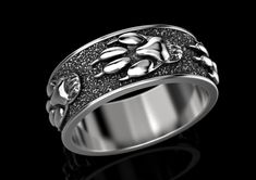 a white gold ring with black diamonds in the center and two hands on each side