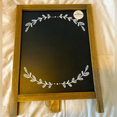 a blackboard with white writing on it sitting on a bed