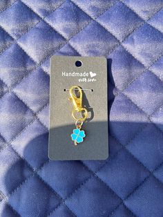 a close up of a pair of scissors on a blue quilted material with a tag attached to it