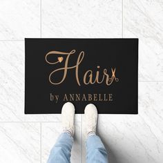 a person standing on the floor with their feet up next to a sign that says hair by annabelle