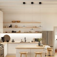 a kitchen with two stools next to an island