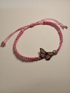 a pink bracelet with a butterfly on it