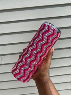 a person holding up a pink and silver case with an interesting design on the side