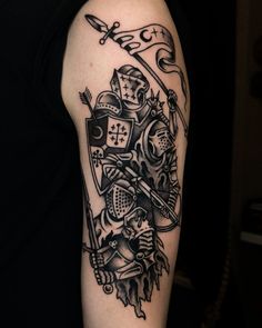 a man's arm with a black and white tattoo design on it, depicting two knights