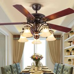 a dining room table with four chairs and a ceiling fan in the middle of it