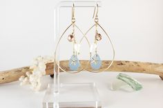 Cultured sea glass is paired together with a tiny starfish as well as a genuine seashell and fire polished glass. All of these dangle within a teardrop hoop and hang from shepherd's hook earwires to form these tropical and fun to wear earrings. The metal used is gold-filled, so it is hypoallergenic and will not tarnish.  From the top of the earwire to the bottom of the teardrop hoop, each earring is about 2 and 3/4ths of an inch in length. These earrings are also available in sterling silver. Ma Cardboard Jewelry Boxes, Beach Earrings, Hawaii Beach, Blue Sea Glass, Gold Filled Earrings, Marine Blue, Matching Necklaces, Sensitive Ears, Beach Jewelry