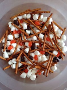 a bowl filled with marshmallows, pretzels and candy canes