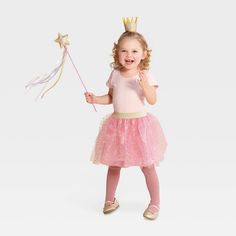 Give a royal, fairytale look to your little one this Halloween with the Toddler Princess Halloween Costume Accessory Set from Hyde & EEK! Boutique™. This three-piece costume accessory set for toddlers includes a glitter-gold crown headband, a star-topped pink wand featuring gold and silver trailing ribbons, and a light pink tutu embellished with gold sequins and a sparkling waistband. Instantly elevating their Halloween experience, the accessory set is perfect for trick-or-treating, family parti Toddler Ballerina Costume, Princess Costume Toddler, Toddler Girl Halloween Costume, Toddler Princess Costume, Pink Wand, Diy Princess Costume, Glinda Costume, Alice Halloween, Princess Costume Kids