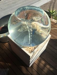 a glass bowl filled with water on top of a wooden table